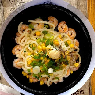 a bowl of noodles with shrimp and corn