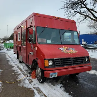 a red food truck parked in a parking lot