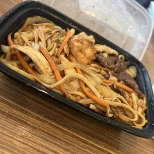 a tray of noodles and meat