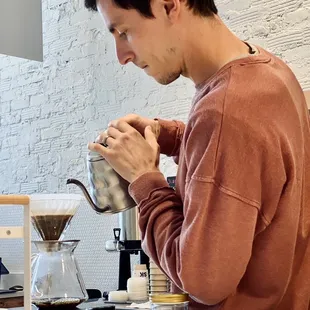 a man pouring a cup of coffee