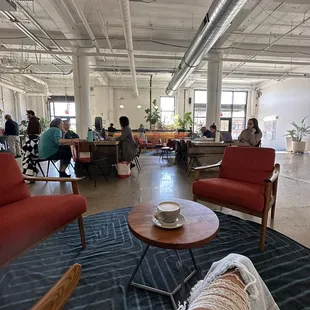 people sitting at tables in a large open space