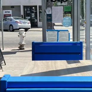 a blue bench in front of a store