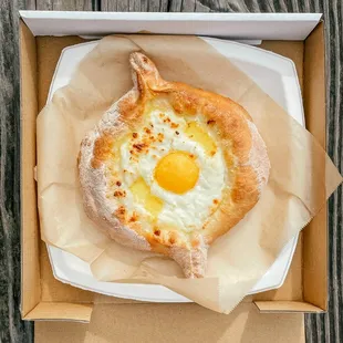 Adjaruli Khachapuri - fluffy bread, cheese, grass-fed butter and egg yolk.