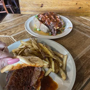 brisket sandwich with fries and a loaded potato.