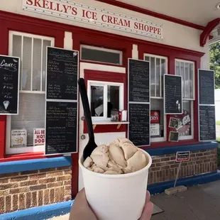 a hand holding a bowl of ice cream