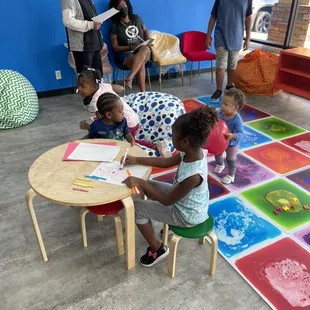 Free play: children of all ages enjoying the paint tiles and coloring.