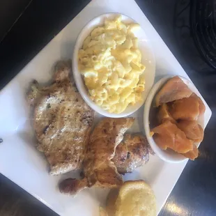 Grilled chicken breast, yams, corn muffin, and macaroni.