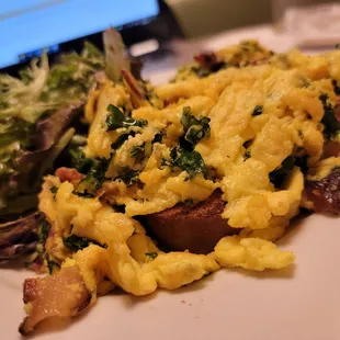 a plate of scrambled eggs and a salad