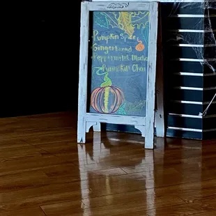 a chalkboard sign with a chalk drawing of a pumpkin