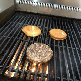 hamburgers cooking on a grill