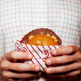 a man holding a hamburger in his hands