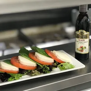 a plate of salad and a bottle of wine