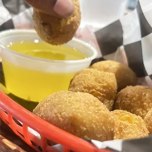 a basket of fried donuts and dipping sauce