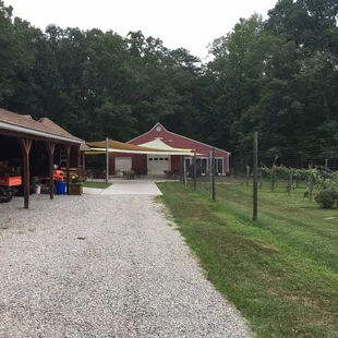 a gravel driveway leading to a barn