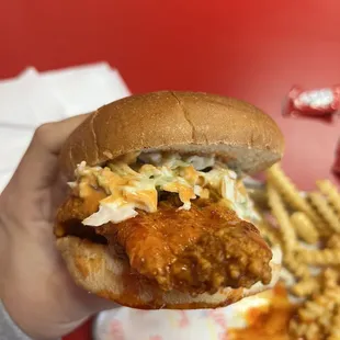 a hand holding a sandwich