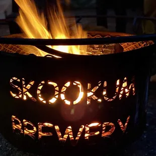 a fire pit with the words skookum brewing written on it