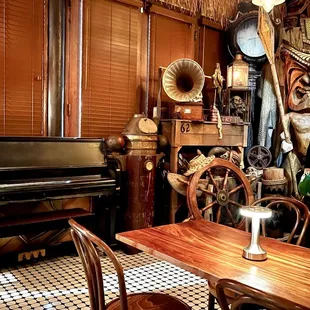 Dining space with a piano and a smorgasbord of nautical and tiki items.