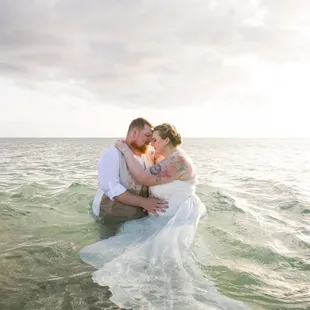 jumping in the water after beach wedding ceremony