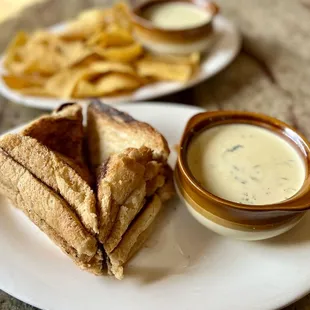 a grilled sandwich and a bowl of dip