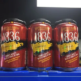 three cans of beer on a shelf