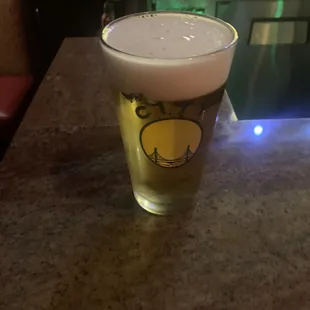 a glass of beer sitting on a counter