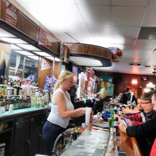 a woman serving customers at a bar