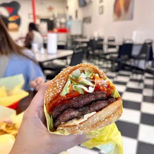 a hand holding a hamburger