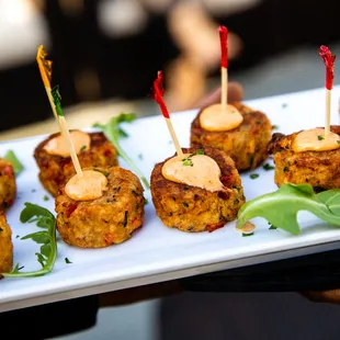 a person holding a plate of appetizers