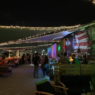 people sitting at tables under string lights