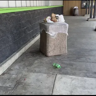 Trash piled up at entrance, and  filthy sidewalk.