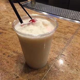 a drink in a plastic cup with chopsticks