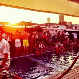 a crowd of people standing around a pool