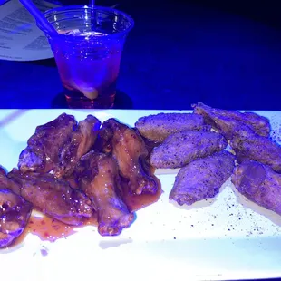 a plate of chicken wings and a drink