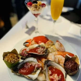 a plate of oysters and a glass of orange juice