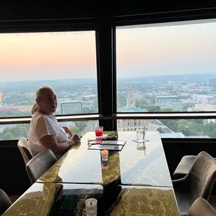 a man sitting at a table overlooking a city