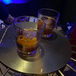 two glasses of whiskey on a table