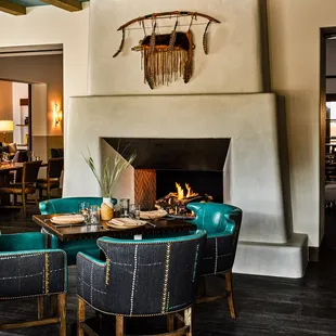 a dining room with a fireplace and blue chairs