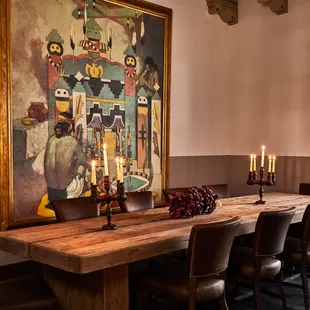 a dining room with a large painting on the wall
