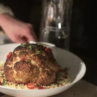 Whole roasted cauliflower with cous cous and tahini/turmeric