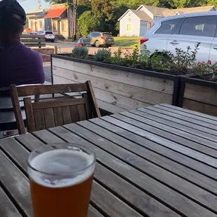 a woman sitting at a table with a glass of beer