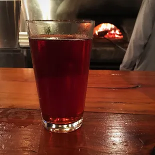 a glass of red wine on a wooden table