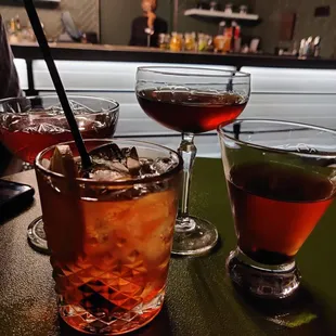 a row of cocktails on a bar counter