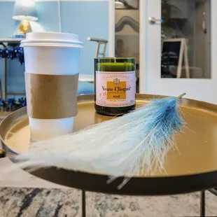 a cup of coffee and a feather on a table