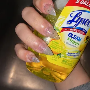 Short stiletto nail with a glitter polish.