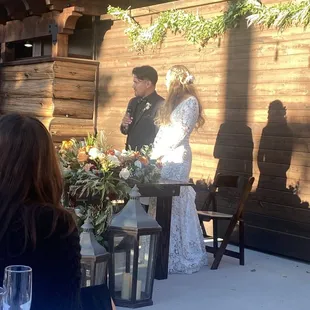 Bride and Groom at their sweetheart table addressing their guests.