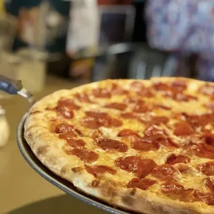 a pepperoni pizza on a pan