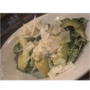 a plate of salad with avocado and parmesan