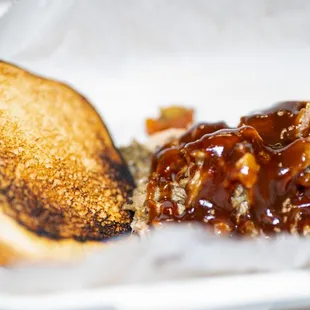 a sandwich and a piece of bread in a styrofoam container