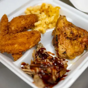a tray of chicken, macaroni, and cheese