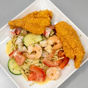 a plate of fried chicken, pasta, and vegetables